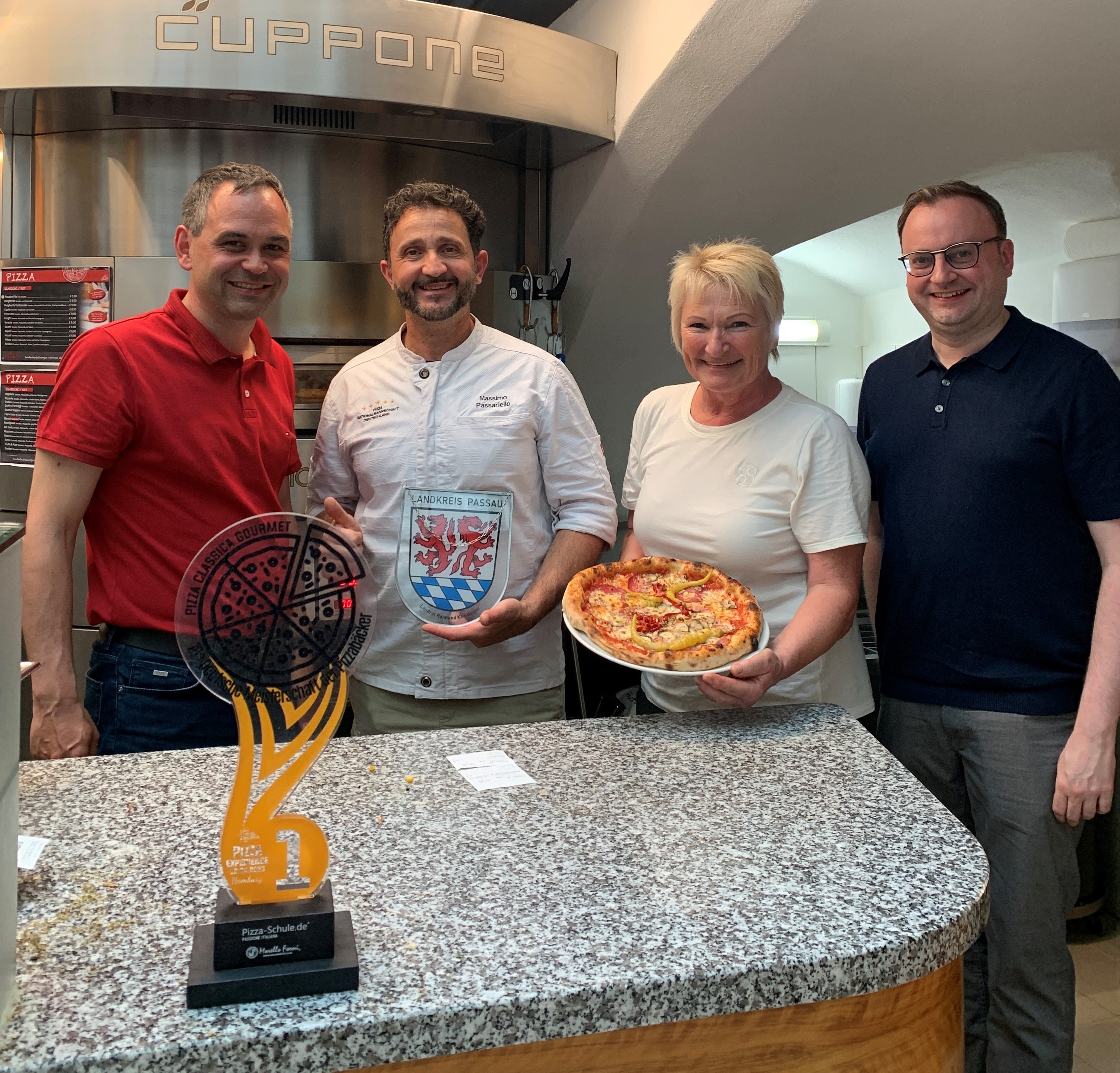 Gratulation an Deutschlands besten Pizzabäcker: Landrat Raimund Kneidinger (v.l.), Massimo Passariello, Seniorchefin Monika Dwyer und Stadtrat Stefan Meyer.