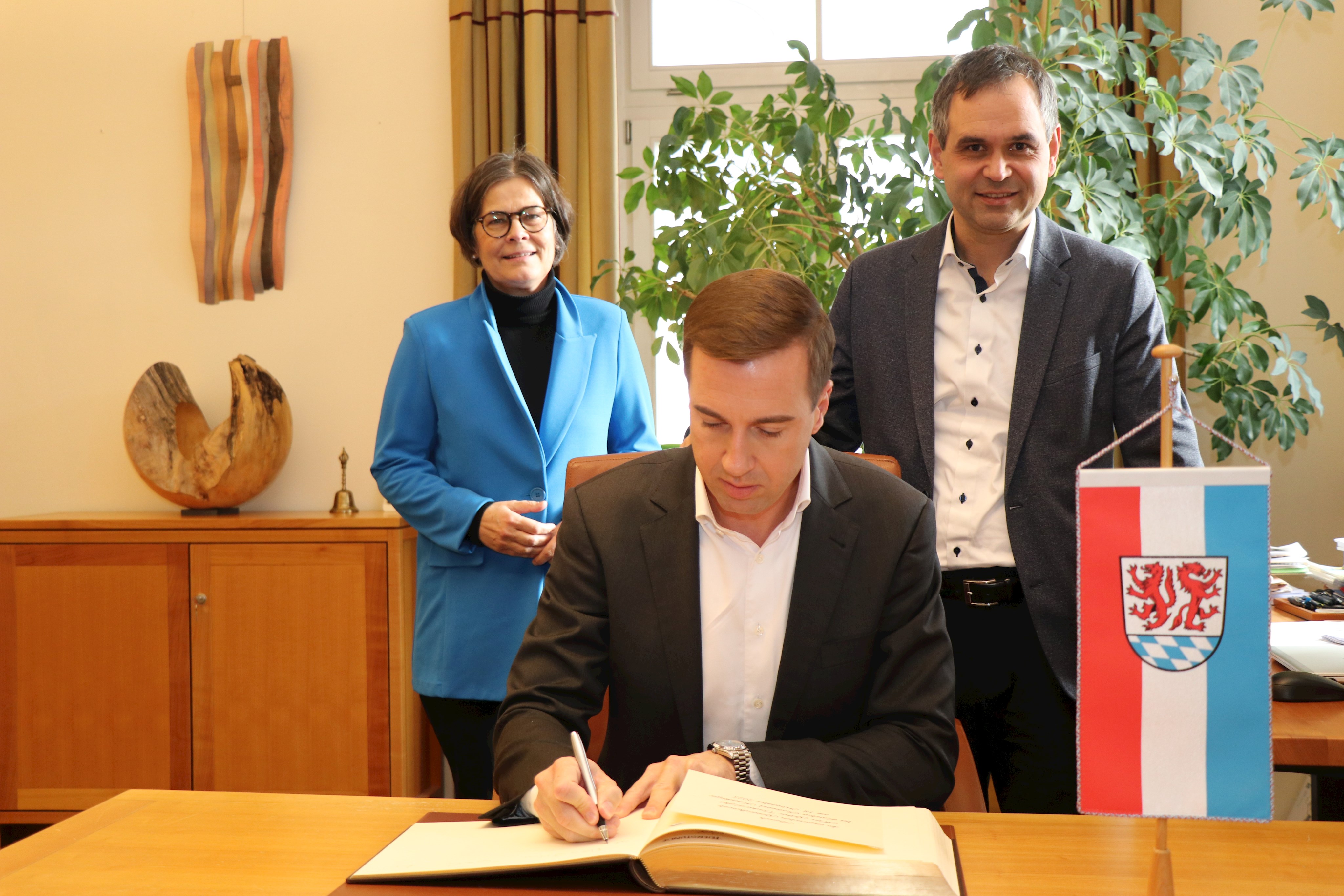 Bei seinem Besuch trug sich der ungarische Generalkonsul Gábor Tordai-Lejkó (vorne) im Beisein von Regierungsdirektorin Verena Schwarz und Landrat Raimund Kneidinger in das Goldene Buch des Landkreises Passau ein.