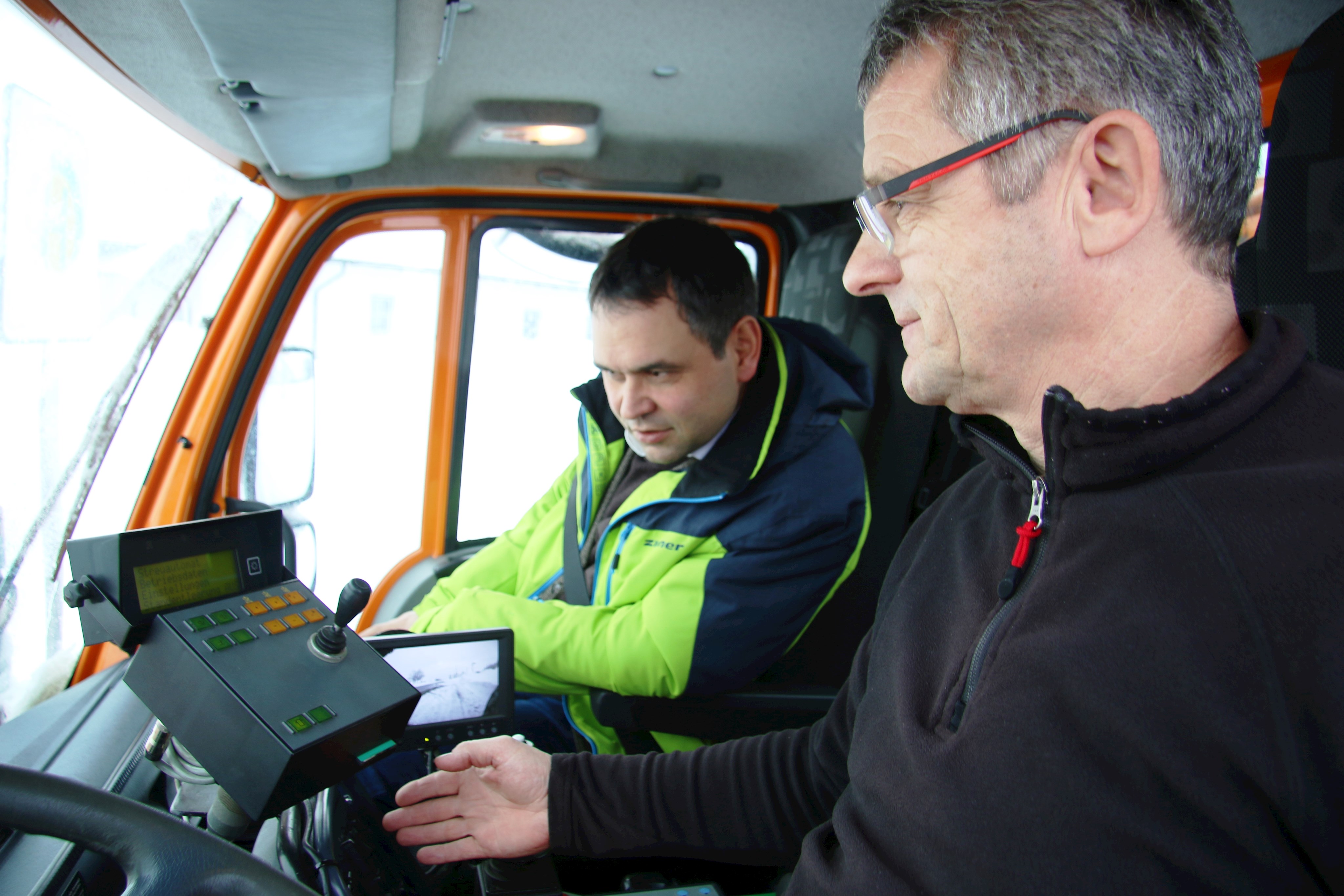 Klaus Schaubschläger (r.) vom Landkreis-Bauhof Wegscheid erklärt Stellvertreter des Landrats Raimund Kneidinger die moderne Technik seines Räumfahrzeugs.