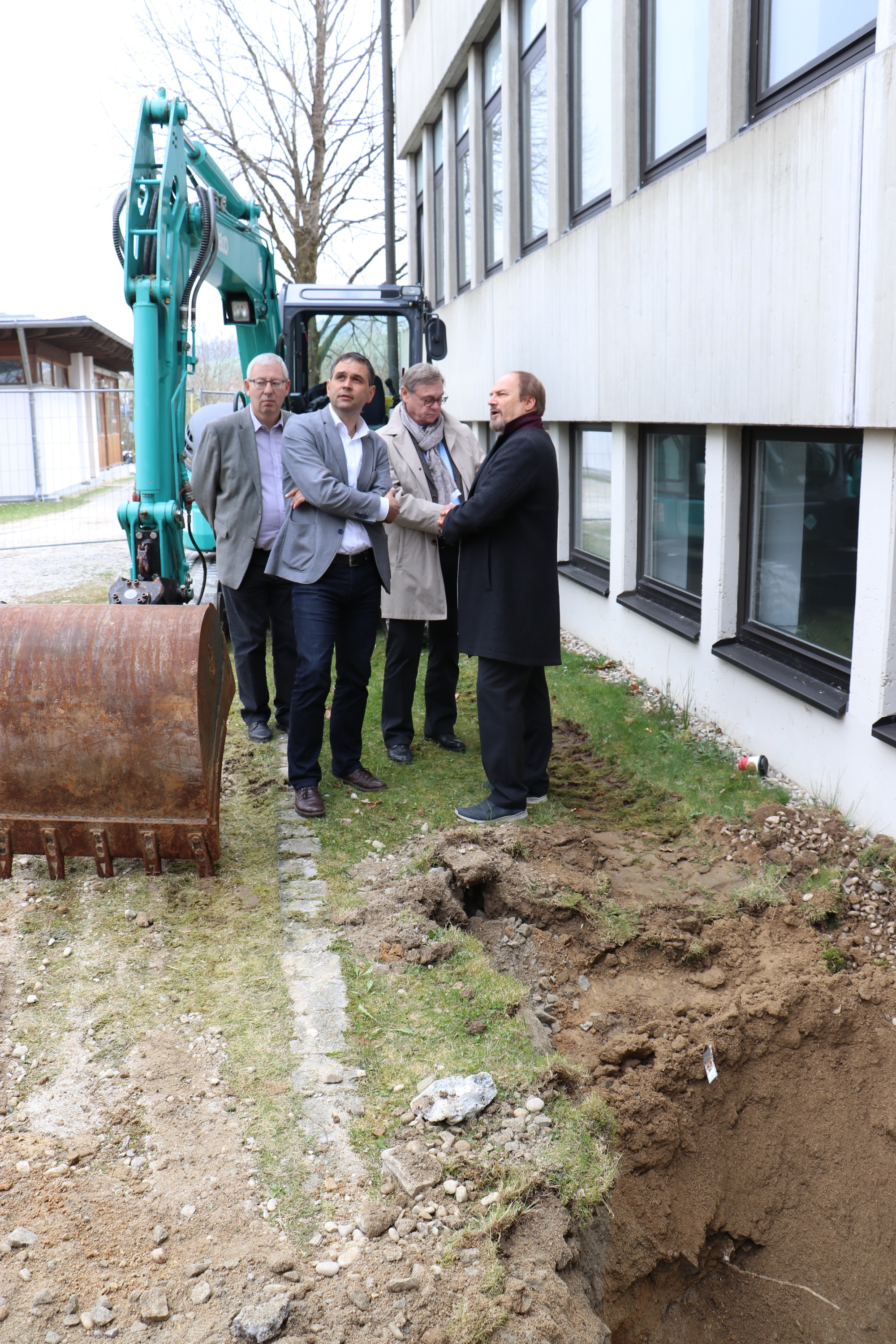 Schulleiter Wolfgang Falk (v.l.), Stellvertreter des Landrats, Raimund Kneidinger, leitender Baudirektor Edgar Küblbeck und Architekt Alexander Feßl begutachten vor Ort die bereits begonnenen Sanierungsmaßnahmen an der Fassade der Realschule Hauzenberg.