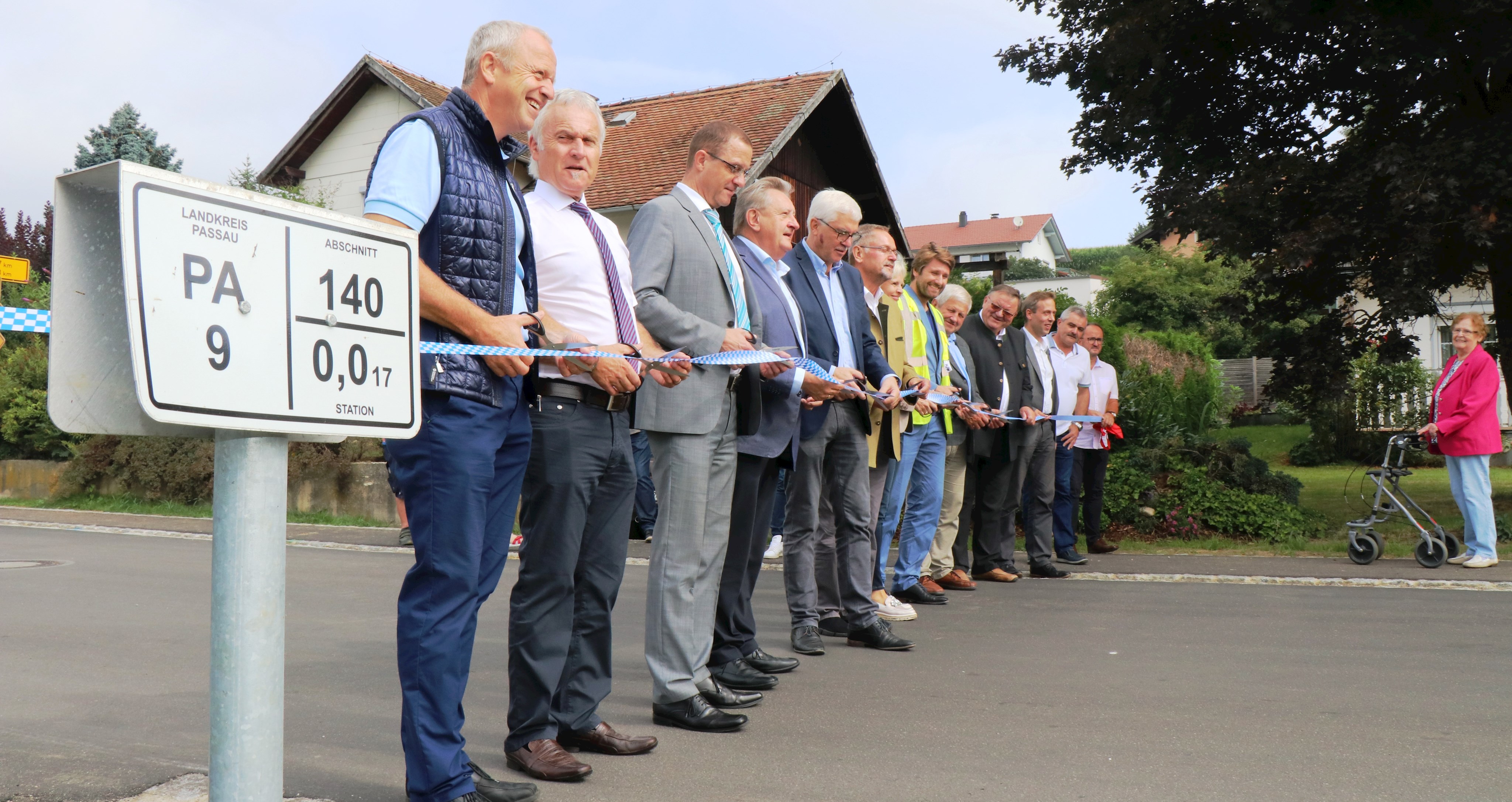 Jetzt ist die PA 9 wieder offiziell freigegeben: Leiter der Kreisstraßenverwaltung Herbert Hebel (v.l.), Leiter des Staatlichen Bauamts Passau (Prüfstelle), Robert Wufka, Regierungsdirektor Armin Diewald, Landrat Franz Meyer und Bürgermeister Manfred Hammer schnitten mit weiteren Vertretern aus Polititk und der Baubeteiligten symbolisch das blau-weiße Band durch. Über den Gehweg auf der Nordseite freuen sich besonders die Anwohner.