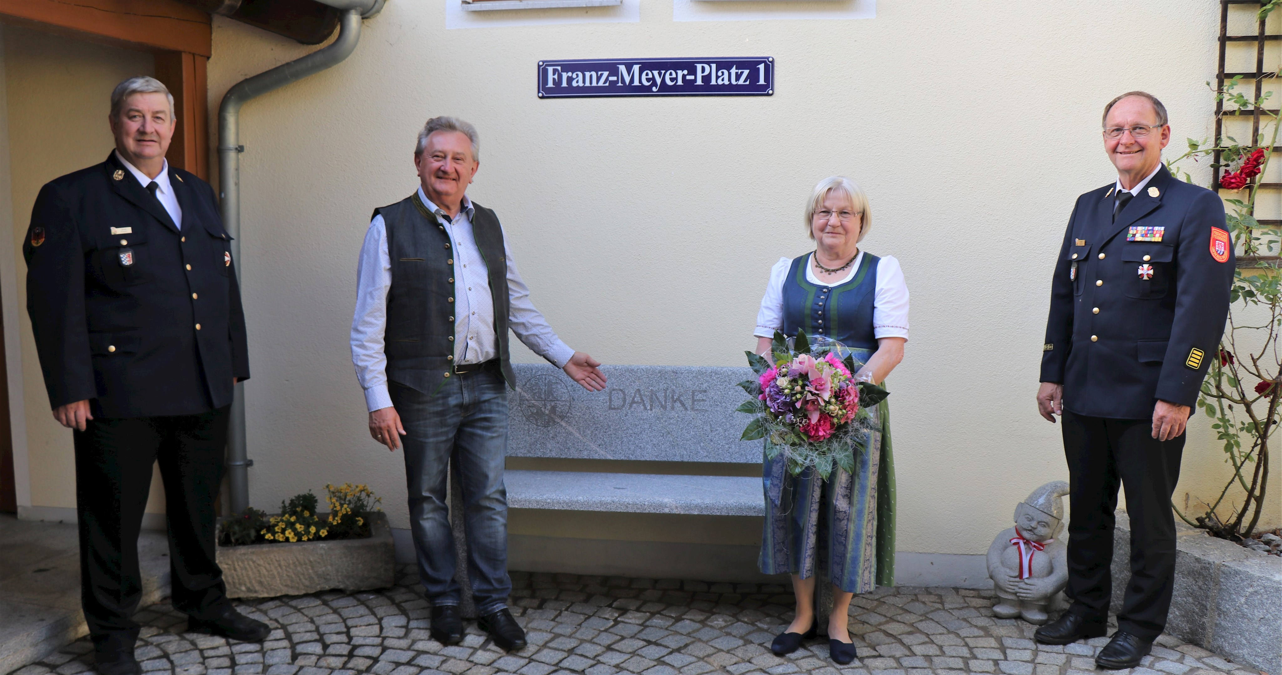 DANKE: Was der Kreisfeuerwehrverband mit Vorsitzendem Alois Fischl (l.) und Kreisbrandrat Josef Ascher (r.) zum Ausdruck bringen wollte, steht in großen Lettern auf der Granitbank, die bei Landrat Franz Meyer und Ehefrau Rosmarie zu Hause einen Ehrenplatz im Eingangsbereich unter dem Schild „Franz-Meyer-Platz 1“ bekommen hat.