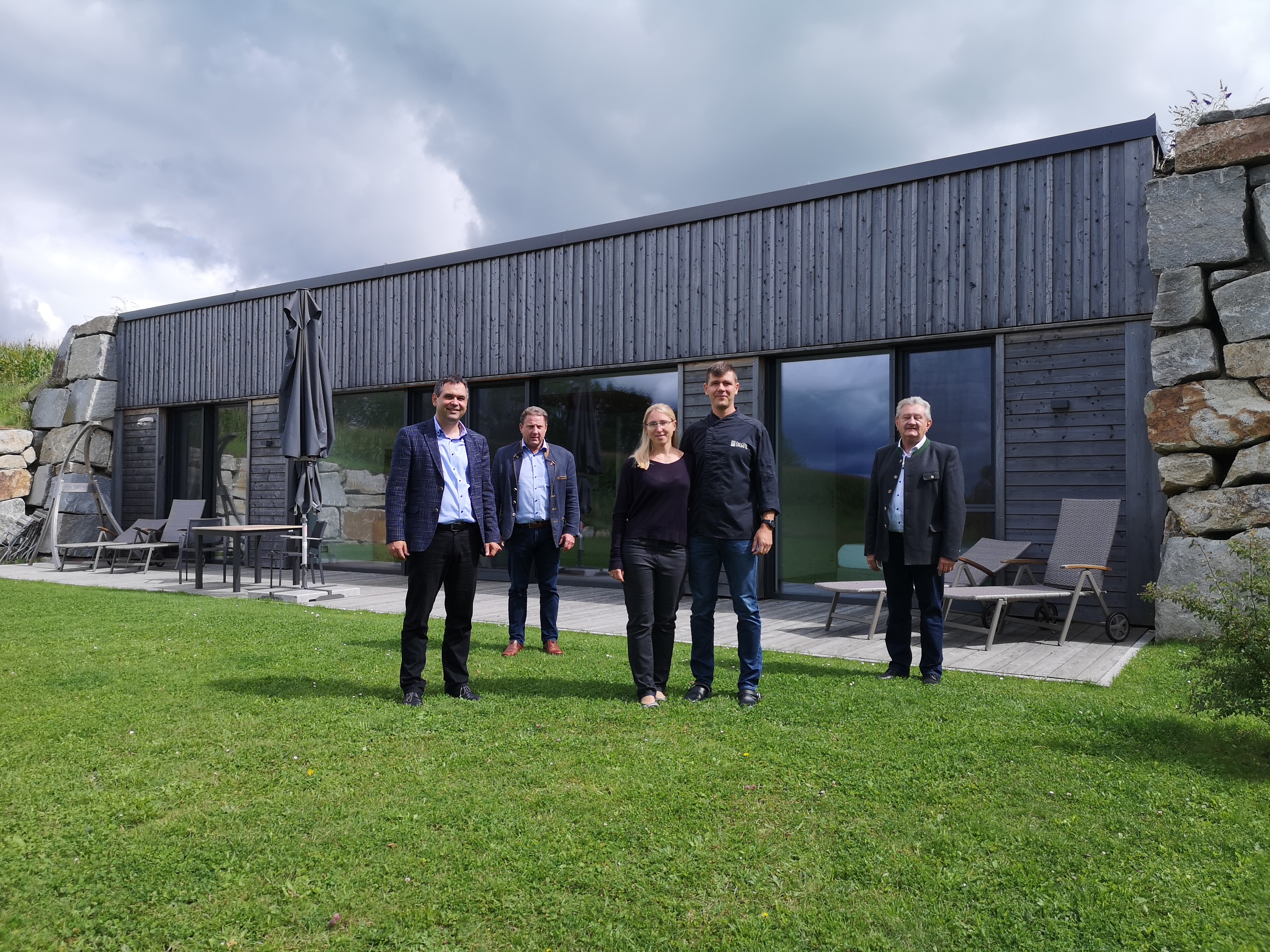 Erdhaus – Ferienhaus – Steinhaus: Nahtlos ins Gelände eingefügt ist das „Stoahäusl“. Landrat Raimund Kneidinger (v.l.), Bürgermeister Adolf Barth und Altlandrat Franz Meyer (rechts) waren beeindruckt, was Andreas und Bianca Haugeneder hier umgesetzt haben.